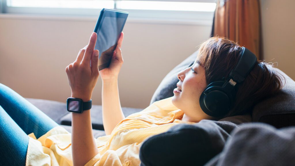 A woman watches TV on her iPad