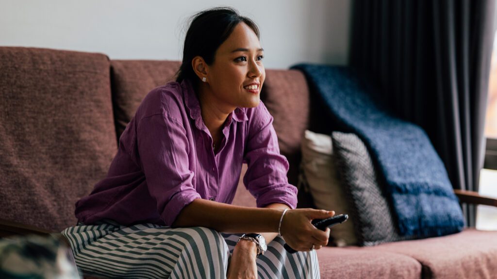 Woman watches TV in her home