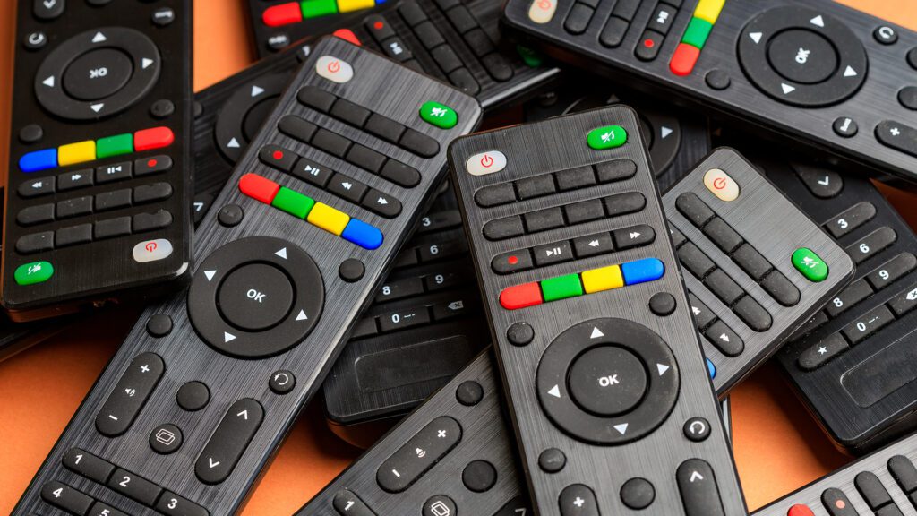 A pile of traditional TV remotes